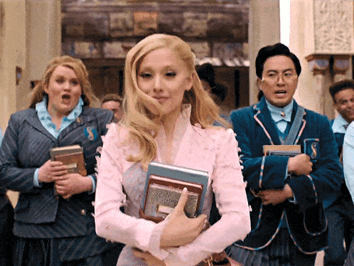 a woman in a pink dress is holding a book with the letter s on the front