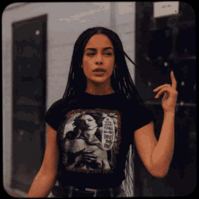a woman wearing a black shirt with a picture of a woman holding a snake
