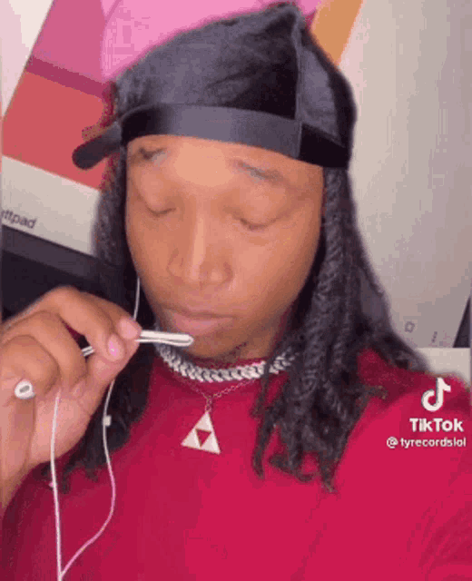 a woman wearing headphones and a headband is holding a pencil in her mouth .