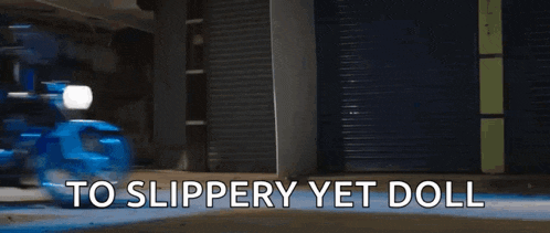a person is riding a motorcycle down a street with the words `` to slippery yet doll '' written on the bottom .