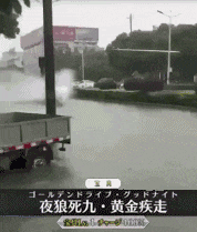 a truck is driving through a flooded street with chinese writing on the bottom