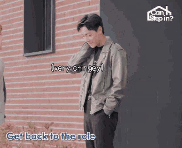 a man stands in front of a brick wall with the words " get back to the role " below him