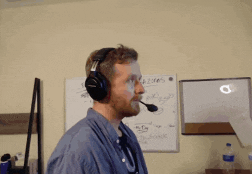 a man wearing headphones and a microphone stands in front of a white board that says a2010s