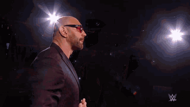 a man wearing sunglasses and a black shirt with a w logo on it