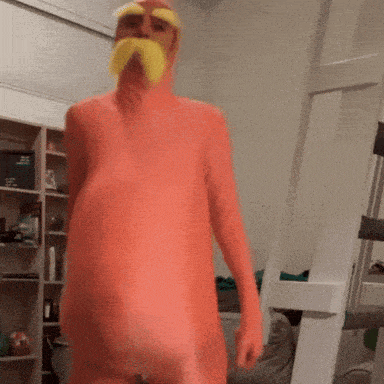 a man in a chicken costume is standing in a room