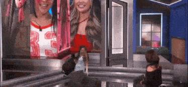 a woman is standing in front of a large screen with a picture of a woman on it .