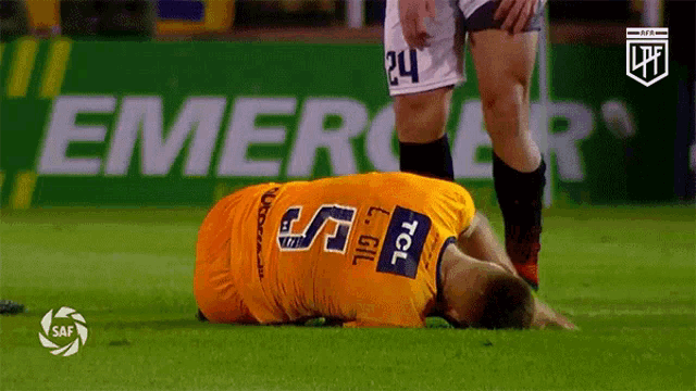 a soccer player with the number 24 on his shorts is laying on the ground