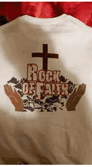 a white t-shirt with a cross and the words rock of faith