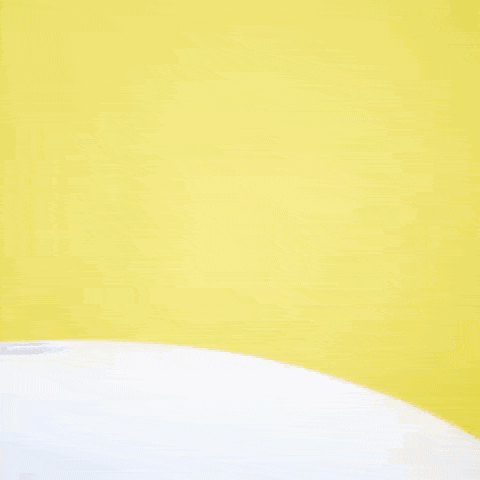 a woman with blonde hair is smiling and making a face in a yellow background .