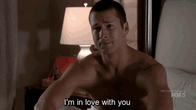 a shirtless man says i 'm in love with you while laying in bed
