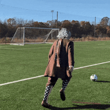 a man in a wig is kicking a soccer ball
