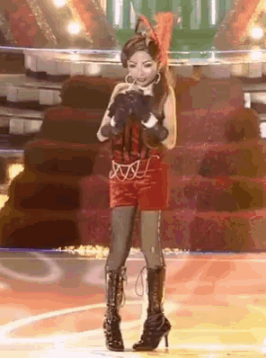 a woman in a cat costume singing into a microphone on a stage