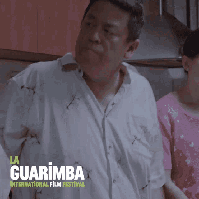 a poster for la guarimba international film festival shows a man and woman in a kitchen