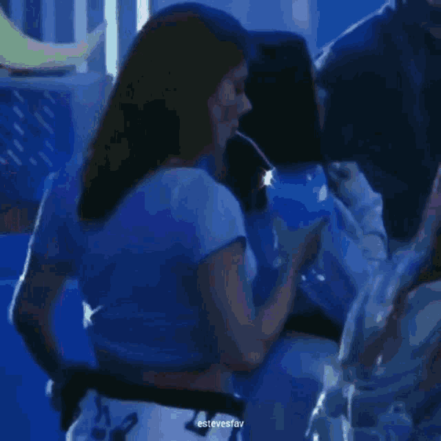 a woman in a white shirt is standing next to a man in a blue room .