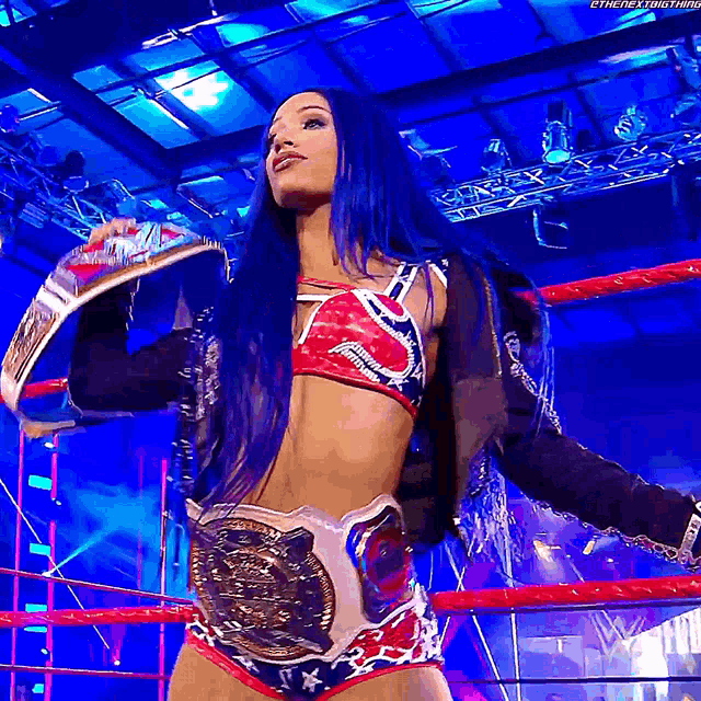 a woman with blue hair is holding a championship belt