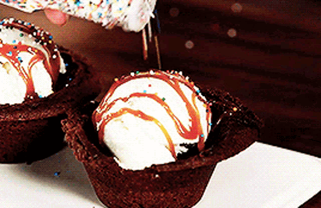 a person is pouring sprinkles on ice cream in a chocolate cup