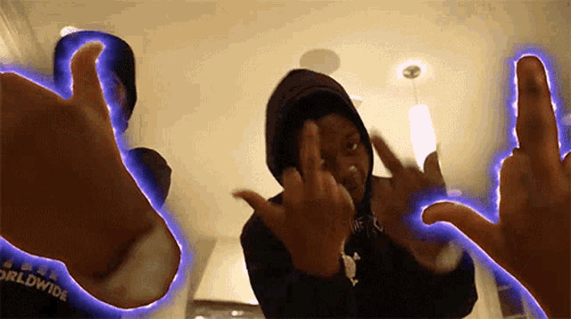 a person in a hoodie giving the middle finger with the word worldwide behind them