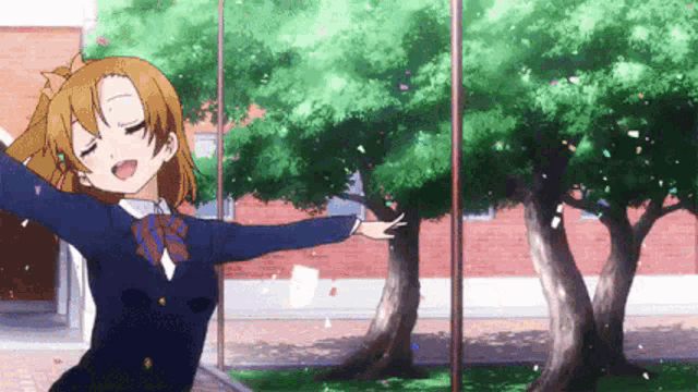 a girl in a school uniform is standing in front of a window with her arms outstretched and confetti flying around her .