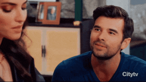 a man and a woman are looking at each other in a citytv advertisement