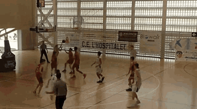 a basketball game is being played in front of a sign that says c.e. lhospitalet