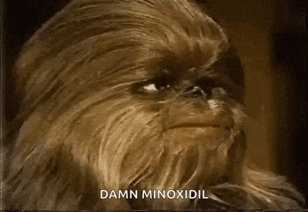 a close up of a chewbacca with the words `` damn minoxidil '' written on the bottom .