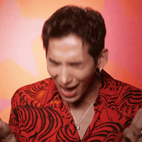 a man wearing a red shirt with a tiger print making a funny face