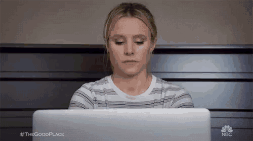 a woman is sitting in front of a laptop computer and looking at it .