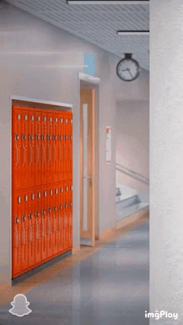 a hallway with orange lockers and a clock hanging on the wall