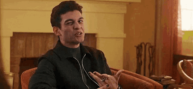 a man is sitting in a chair making a funny face while smoking a cigarette .