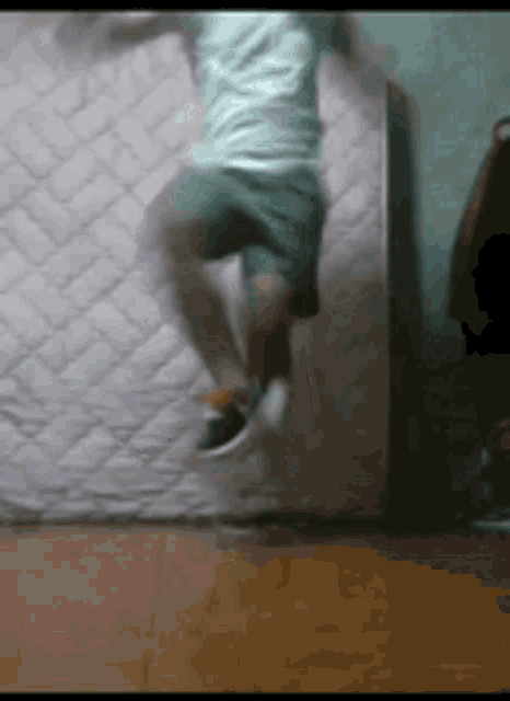 a person is jumping in the air while laying on a mattress .