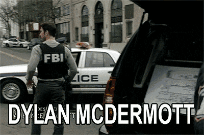 a man in a fbi vest standing in front of a police car
