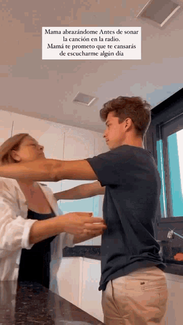 a man and a woman are hugging in a kitchen with a caption that says mama abrazandome antes de sonar