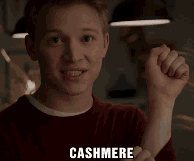 a man in a red sweater is holding his fist up and the word cashmere is on the bottom right