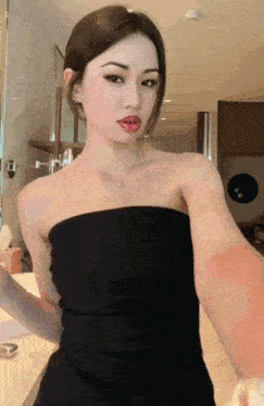 a woman in a black strapless top takes a selfie