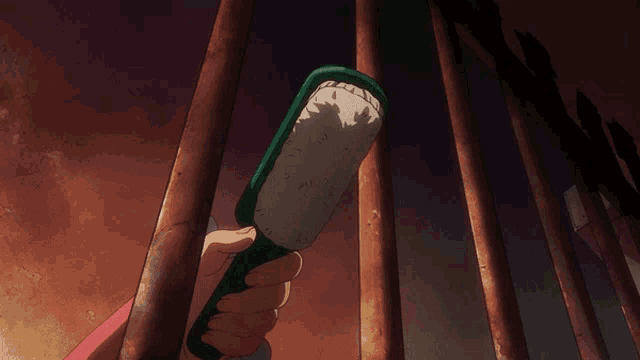 a person is holding a green container with rice on it behind bars