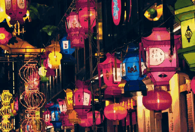 a bunch of colorful lanterns are hanging from a rope
