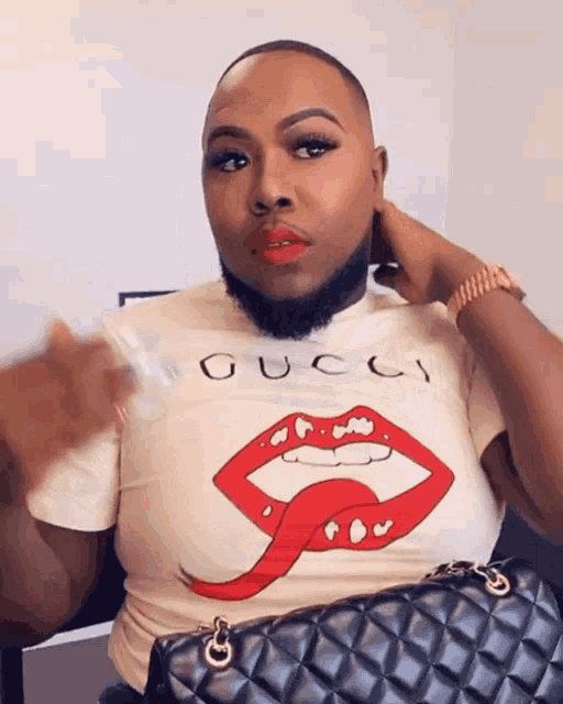 a man wearing a white gucci shirt with red lips