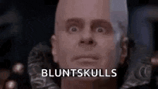 a close up of a bald man 's face with the words bluntskulls written in the corner .