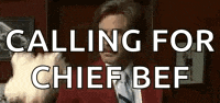 a man in a red suit and tie is calling for chief beef .