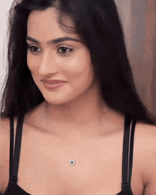 a woman wearing a black bra and a necklace