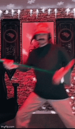 a man in a santa hat is dancing in a room with a red wall .