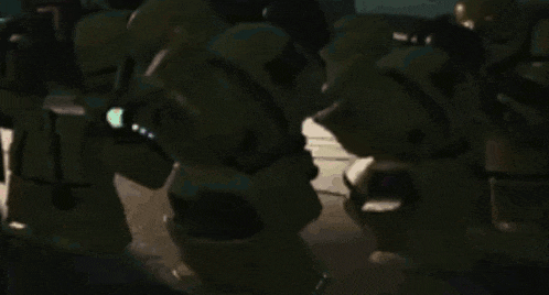 a group of soldiers are standing next to each other in a dark room .