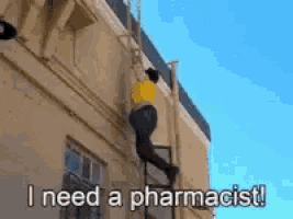 a man is climbing up the side of a building and says i need a pharmacist !