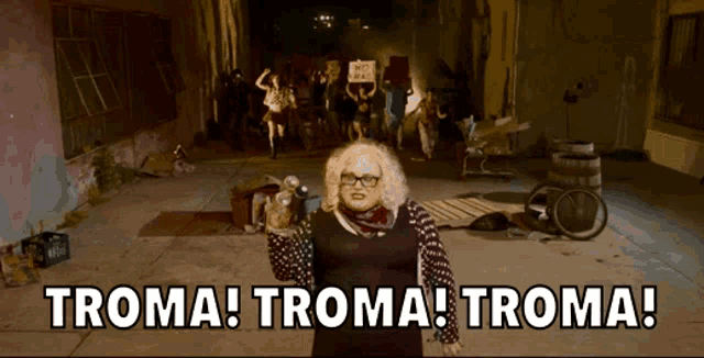 a woman holding a microphone says troma