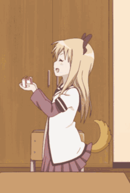 a girl with a tail is holding a small red box in her hand