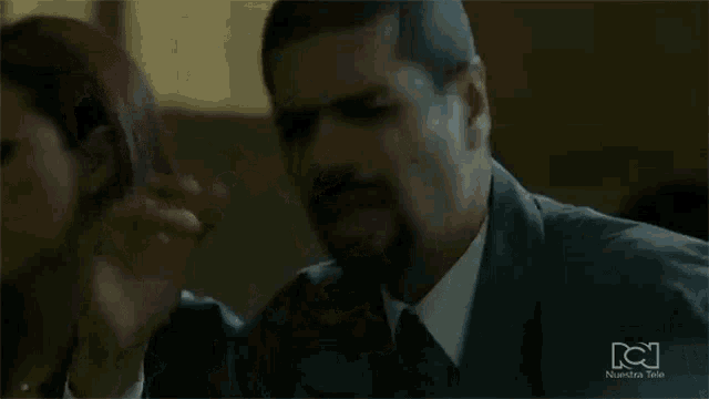 a man in a suit and tie is being comforted by a woman