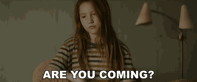a girl with red hair is sitting in a chair with the words are you coming written below her