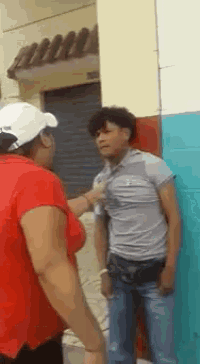 a woman in a red shirt is standing next to a man in a gray shirt