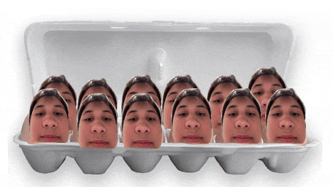 a styrofoam egg carton filled with a bunch of faces