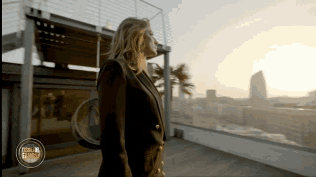 a woman standing on a balcony with a circle around her that says ' vogue fashion '
